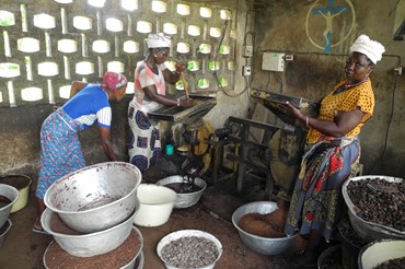 Women process grain in a mill