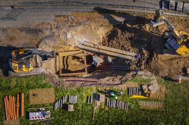 Drone photo of a construction site with excavators and workers performing excavation work.